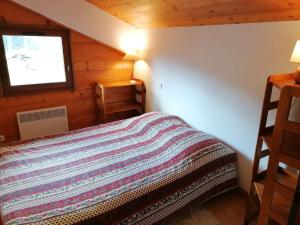 ein Schlafzimmer mit einem Bett in einer Holzhütte in der Unterkunft Appartement Le Grand-Bornand, 3 pièces, 6 personnes - FR-1-241-61 in Le Grand-Bornand