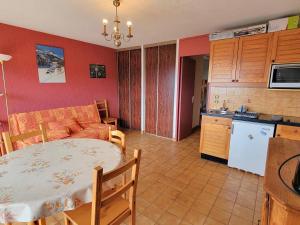 Una cocina y una sala de estar con una mesa y un sofá. en Appartement 6 pers. proche station avec balcon et parking privatifs - FR-1-393-90, en Saint-Michel-de-Chaillol