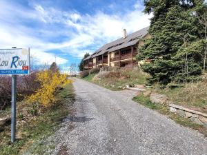 una carretera al lado de una casa con un cartel en Appartement 6 pers. proche station avec balcon et parking privatifs - FR-1-393-90, en Saint-Michel-de-Chaillol