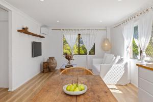 uma cozinha e sala de estar com uma mesa de madeira em Boho Style 2BR apartment in Kingscliff by uHoliday em Kingscliff