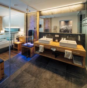 a bathroom with two sinks and a large mirror at Bergresort Das Jochelius in Nauders