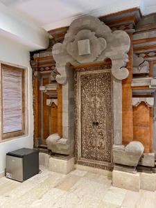 a room with a large door in a building at Honeymoon Guesthouse in Ubud