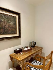 a table in a room with a painting on the wall at Honeymoon Guesthouse in Ubud