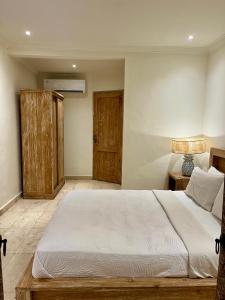 a bedroom with a large bed and a wooden cabinet at Honeymoon Guesthouse in Ubud