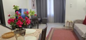 a vase filled with pink flowers on a table at THOMAS LUXURY APARTMENT in the historical center of Ioannina in Ioannina