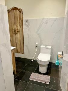 bagno con servizi igienici bianchi e lavandino di Honeymoon Guesthouse ad Ubud