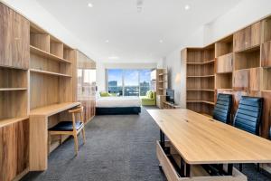 a room with wooden shelves and a desk and a bed at Vision Apartments On Morphett with Parking in Adelaide