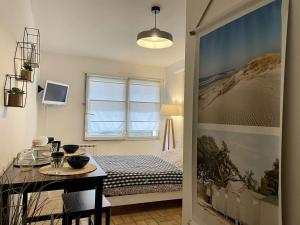 a bedroom with a bed and a table and a window at Appartement Noirmoutier-en-l'Île, 1 pièce, 2 personnes - FR-1-224B-146 in Noirmoutier-en-l'lle