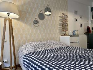 a bedroom with a blue and white bed and a lamp at Appartement Noirmoutier-en-l'Île, 1 pièce, 2 personnes - FR-1-224B-146 in Noirmoutier-en-l'lle