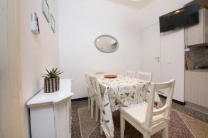 une salle à manger avec une table et des chaises blanches dans l'établissement 244 - Casa Ludo, Centro Storico,140m dalla Baia del Silenzio PATRIMONIO UNESCO spiaggia e mare, à Sestri Levante