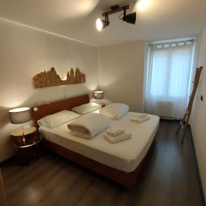 a bedroom with a bed with white sheets and a window at La Bouganville in Arco +27 photos