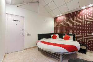 een slaapkamer met een groot bed met rode kussens bij OYO Nova Dumas Homestay in Surat