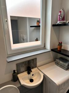 ein Bad mit einem Waschbecken und einem Spiegel in der Unterkunft The Easy Inn Brighton in Brighton & Hove