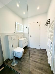een badkamer met een toilet en een glazen douche bij ROTH Apartments Velbert-Mitte in Velbert