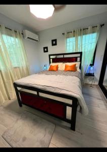 a bedroom with a large bed with orange pillows at E & J Lifestyle in Río San Juan