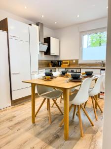 een keuken met een houten tafel en witte kasten bij ROTH Apartments Velbert-Mitte in Velbert