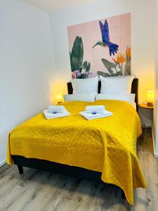 een slaapkamer met een geel bed en 2 handdoeken erop bij ROTH Apartments Velbert-Mitte in Velbert