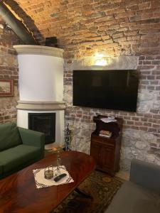 a living room with a fireplace and a flat screen tv at Dom Pugetów in Krakow