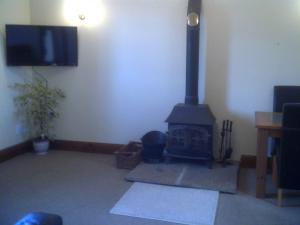 ein Wohnzimmer mit einem Kamin und einem Flachbild-TV in der Unterkunft Knotts Farm Holiday Cottages in Lancaster