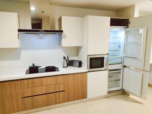 a kitchen with white cabinets and a refrigerator at Gold Crest, One bed Suite in Lahore
