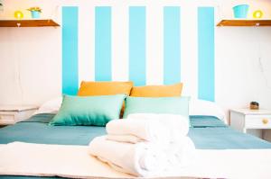 1 dormitorio con cama y paredes de rayas azules y blancas en La Casita Surf, en Famara