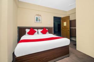 a bedroom with a large bed with red pillows at OYO Hill Grand Himalaya in Darjeeling