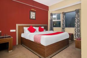 a bedroom with a bed with red walls at OYO Hill Grand Himalaya in Darjeeling