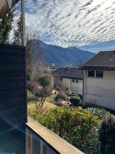 uma vista para uma casa com montanhas ao fundo em bloom: See Berge moderne Ausstattung für 2-6 Pers em Tegernsee