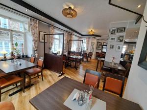 a restaurant with tables and chairs and a bar at Hotel Gute Quelle in Beilstein