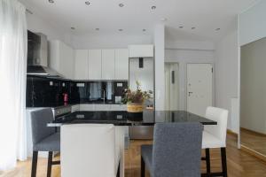 a kitchen with white cabinets and a table and chairs at One Bedroom Apt w/ Balcony in Athens