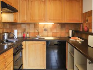La cuisine est équipée de placards en bois, d'un évier et d'un lave-vaisselle. dans l'établissement Apartment Colline 8 by Interhome, à Champex-Lac