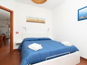 um quarto com uma cama azul num quarto branco em Holiday Home Baldassarre by Interhome em Termini