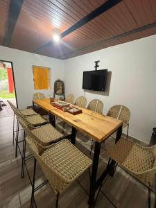 mesa de madera con sillas y TV en la pared en Las 5 Quintas - Acogedora casa en San Rafael