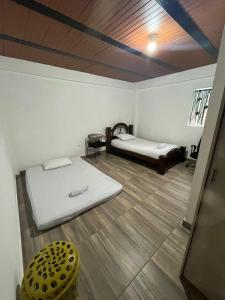 Habitación con 2 camas y taburete amarillo en Las 5 Quintas - Acogedora casa en San Rafael
