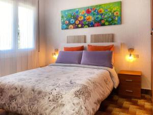 トッサ・デ・マールにあるApartment Aquarius by Interhomeのベッドルーム1室(ベッド1台付)が備わります。壁には絵画が飾られています。