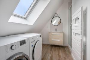 Un lavadero con lavadora y ventana. en Le Pouliguen - Maison lumineuse avec jardin, en Le Pouliguen