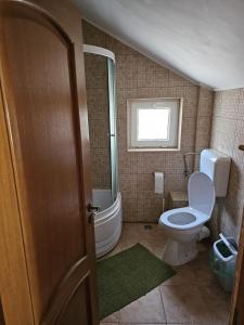 a small bathroom with a toilet and a window at Vila Călin Sinaia in Sinaia
