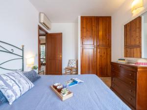a bedroom with a blue bed with a wooden dresser at Holiday Home Carlo-2 by Interhome in Notteri
