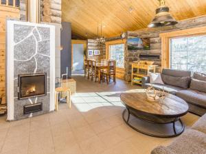 ein Wohnzimmer mit Couch und Kamin in der Unterkunft Holiday Home Muuttohaukka by Interhome in Ruka