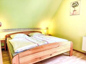 a wooden bed in a room with green walls at Apartment Gebauer-1 by Interhome in Fuchshofen