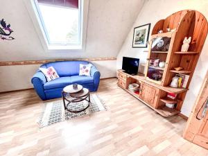 ein Wohnzimmer mit einem blauen Sofa und einem TV in der Unterkunft Apartment Gebauer-1 by Interhome in Fuchshofen