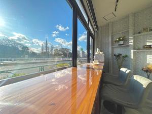 Zimmer mit einem Schreibtisch und einem großen Fenster in der Unterkunft 尹府F栋 天空树景观 in Tokio