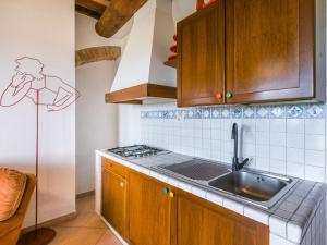 eine Küche mit Holzschränken und einem Waschbecken in der Unterkunft Apartment Casa Renai a San Gimignano-6 by Interhome in San Gimignano