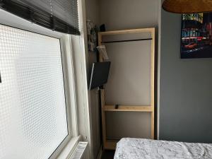 Schlafzimmer mit einem Fenster und einer Tür mit einem TV in der Unterkunft The Easy Inn Brighton in Brighton & Hove