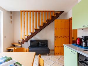 a kitchen with a staircase with a chair and a table at Apartment Dromaè-2 by Interhome in Mezzolago