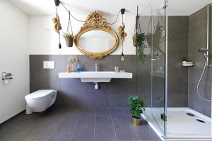 uma casa de banho com um lavatório, um WC e um espelho. em Gantrisch Lodge Ottenleuebad em Guggisberg