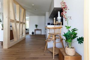 sala de estar con silla de madera y escalera en Gantrisch Lodge Ottenleuebad, en Guggisberg