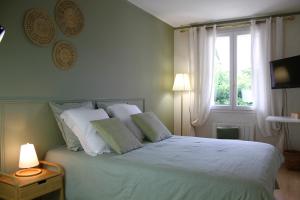 Aincourt的住宿－Maison Hermitage，卧室配有带白色枕头的床和窗户。