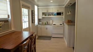 a kitchen with white cabinets and a wooden table at Barra Villa Resort House I in Fort Myers