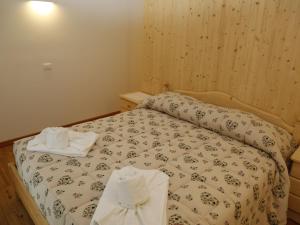 a bedroom with a bed with two towels on it at Apartment Cjase Fravins-3 by Interhome in Raveo